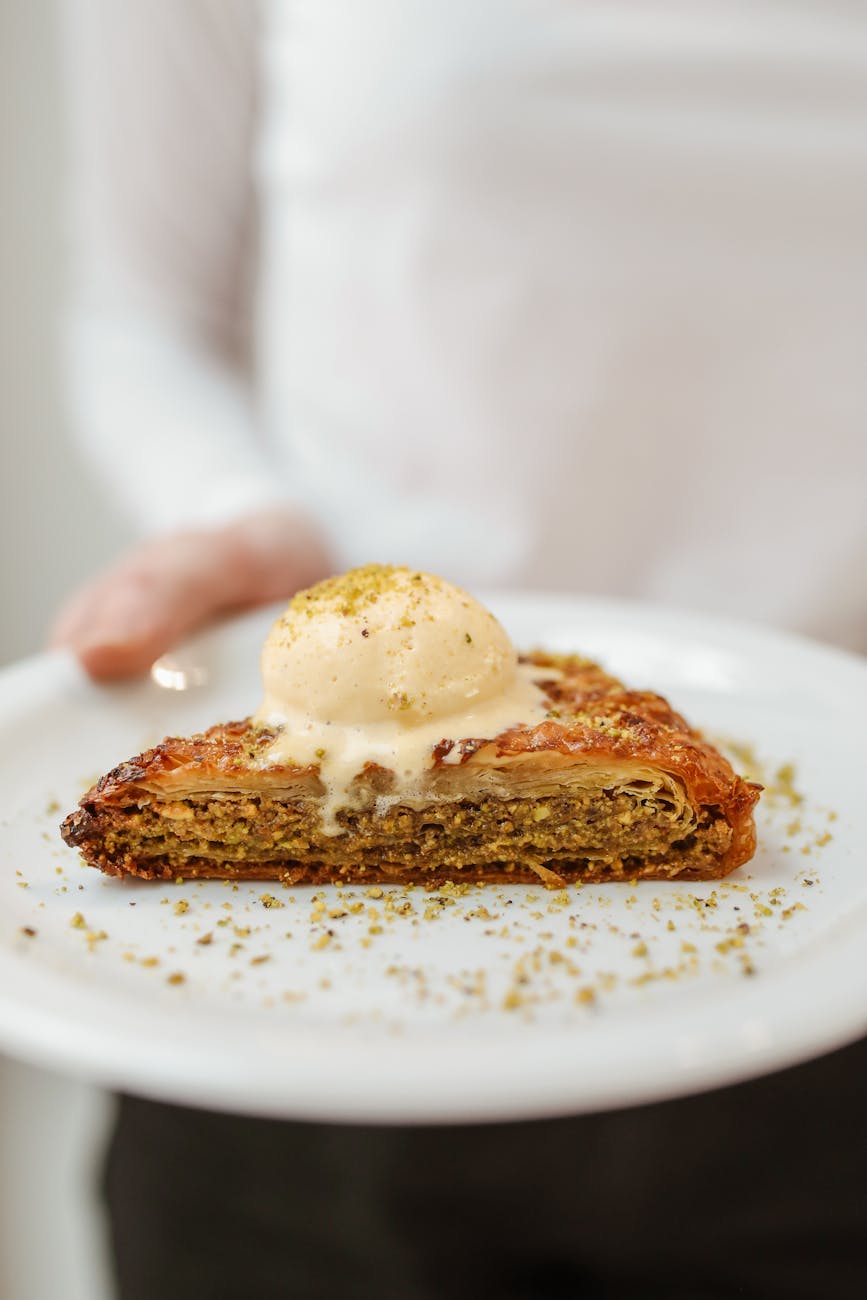 layered pastry dessert with ice cream on a ceramic plate