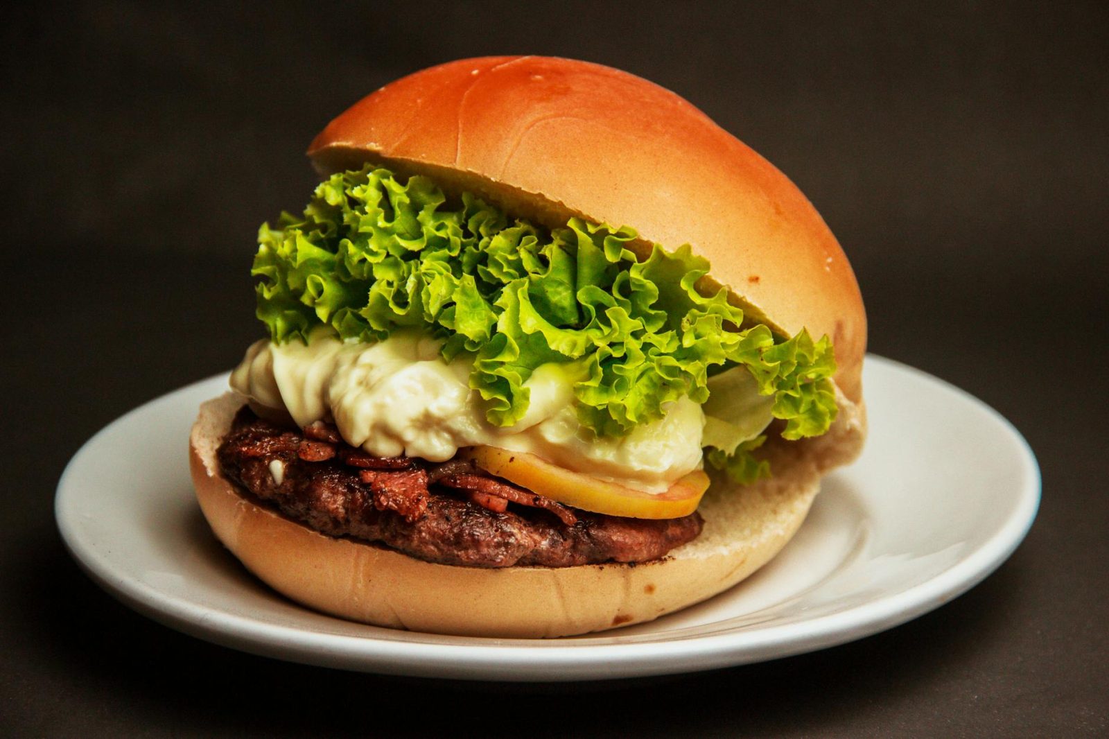 burger with lettuce and cheese on a white plate