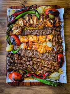 a mix of grilled meat with red and green peppers and tomatoes