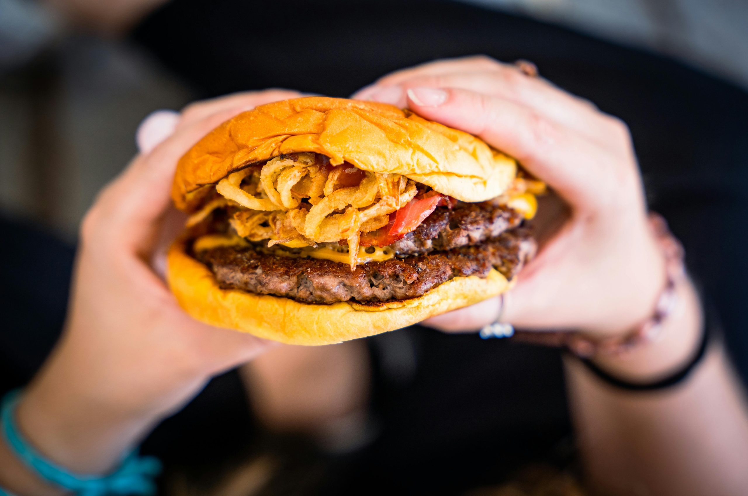 A person holding a hamburger
