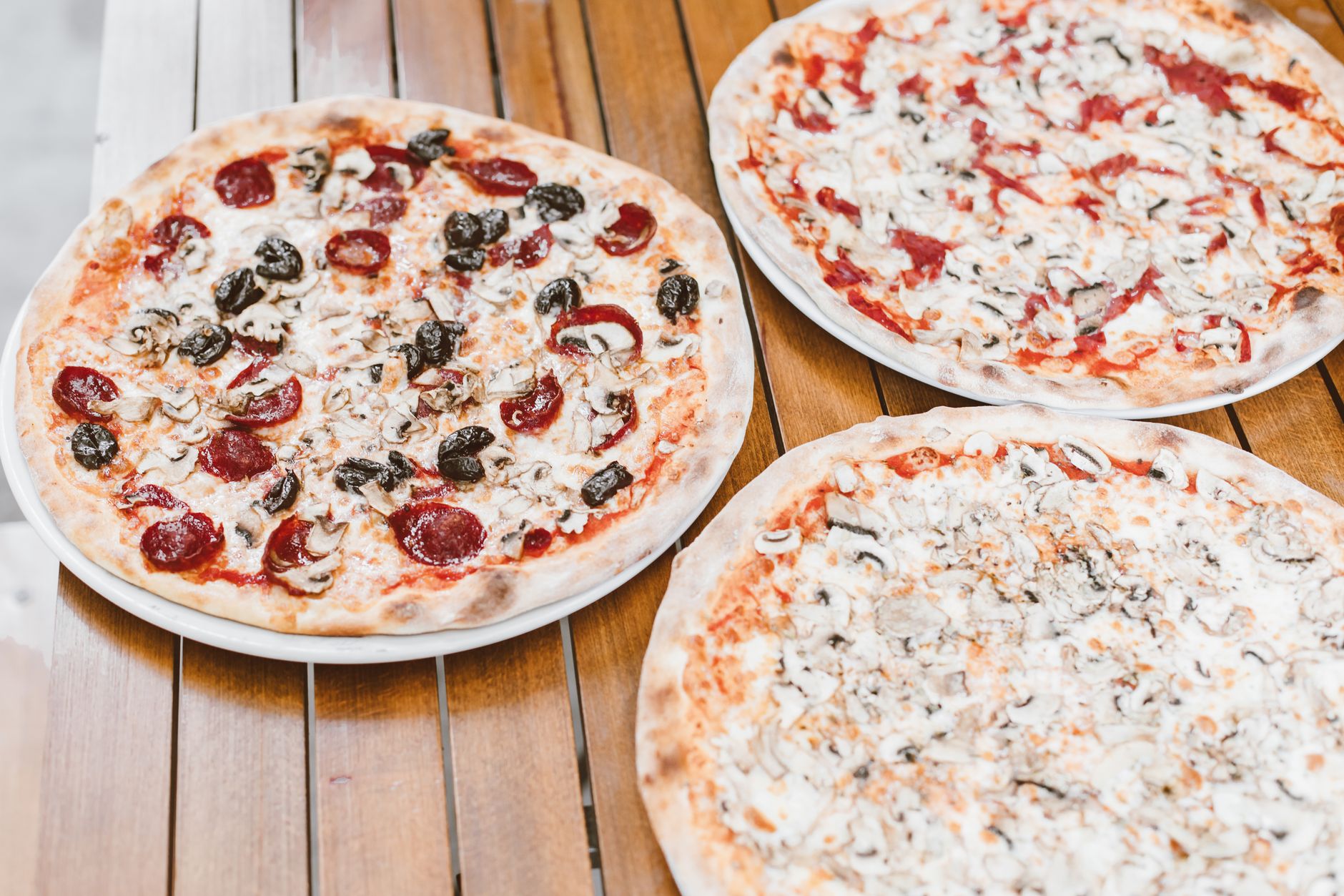 pizzas on brown wooden table