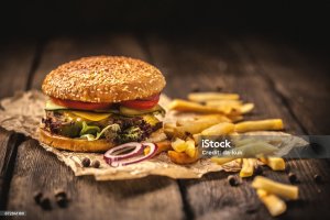 Tasty hamburger with french fries on wooden table